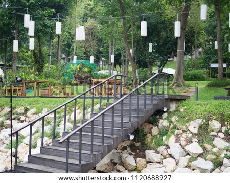 old wooden stair in the garden with the white paper lamp and stone and wooden table Royalty-Free Stock Photo #1120688927