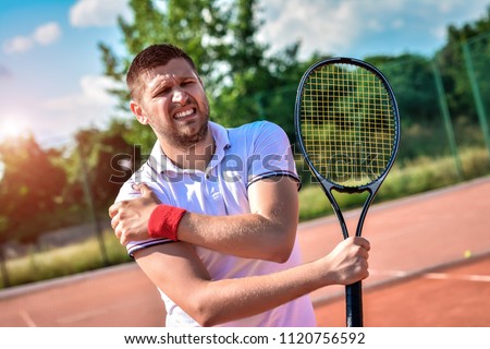 Shot of a tennis player with a shoulder injury on a clay court Royalty-Free Stock Photo #1120756592