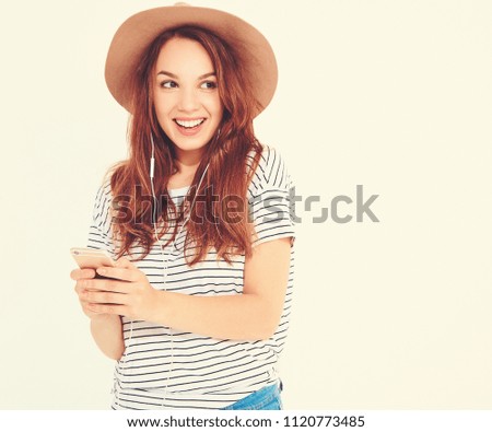 beautiful smiling brunette woman girl in casual hipster summer clothes with no makeup in brown hat listening music in smartphone with headphones
 isolated on white. Dancing