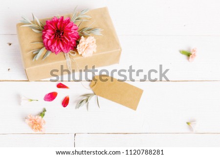 Festive flowers red dahlias composition with a gift on the white background. Overhead top view, flat lay. Copy space. Birthday, Mother's, Valentines, Women's, Wedding Day concept