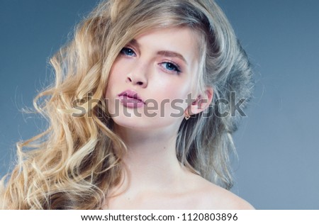 Beautiful blonde model girl with pink lipstick and curly blonde long hair female portrait