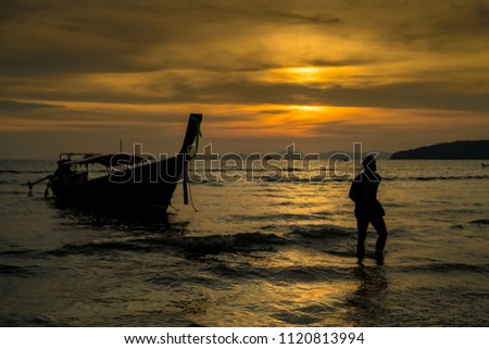 silhouette Man and Boat in Beach with Sunset Background 
