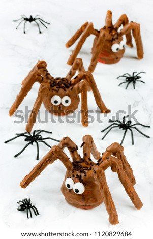 Halloween spider cakes with candy eyes in chocolate, Halloween treats for kids