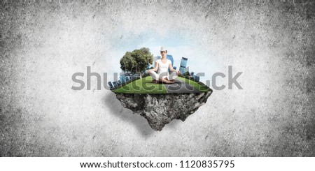 Woman in white clothing keeping eyes closed and looking concentrated while meditating on flying island in the air with gray wall on background. 3D rendering.