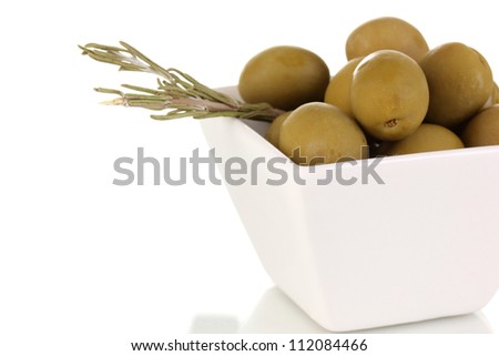 Green olives in white bowl with rosemary isolated on white