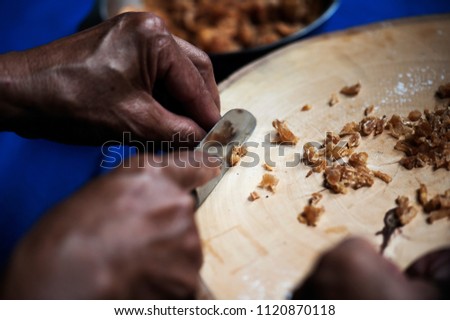 Cook is cutting dried longan as a mixture