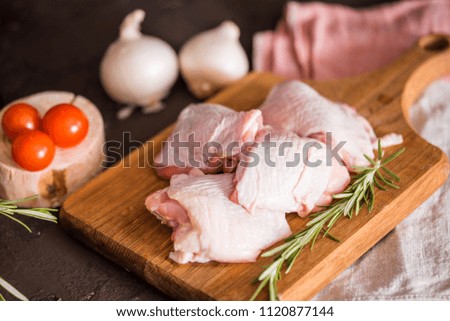 Chicken for grilled, spices, herbs, tomatoes, mushrooms on dark background, top view. Raw meat chicken for cooking. Delicious balanced food concept