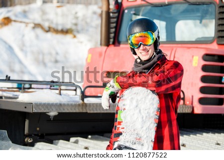 Image of smiling man in helmet with snowboard