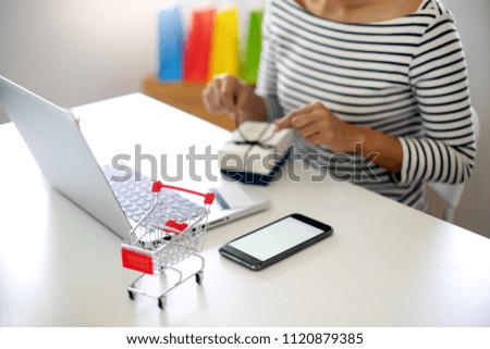 woman sit at computer table look at the product pack open or packing theme  about shopping online sale and buy order