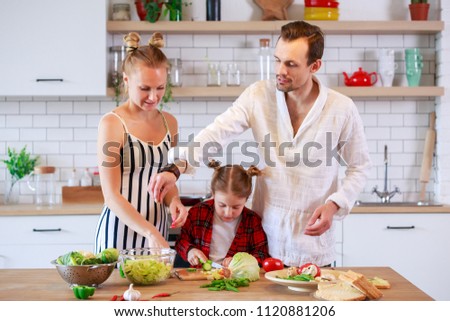 Photo of young parents with daughter preparing food
