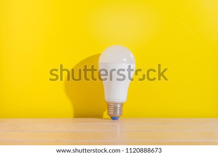 White light bulb on wooden table with Yellow background.Fresh idea concept.Bright idea concept.Copy space.