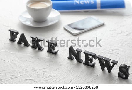Words FAKE NEWS made of letters on textured table