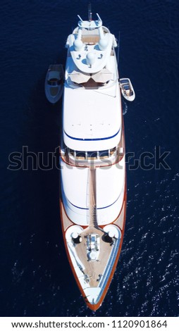 Aerial drone bird's eye top view photo of luxury yacht docked in deep blue mediterannean port
