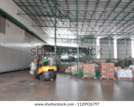 blurred picture.  A lift truck is moving goods inside a warehouse.