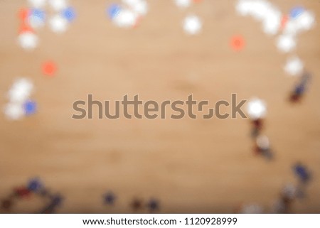 Confetti stars on wooden background. 4th July, Independence day, card, invitation in usa flag colors. Top view, empty space. Blured