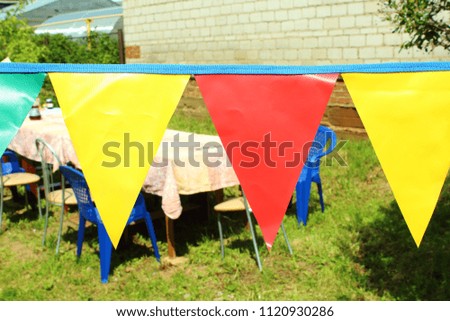 Festive table outdoors. Birthday. Garlands of flags of triangles. Close-up. Background.