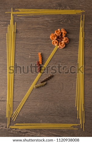 Conceptual picture with pasta in the kitchen. The food is lined with a flower in the frame