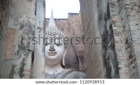 The Thailand great bhuddha statue at the ancient place in Sukhothai province Thailand that built from ancient rock and surround with ancient brick wall  in a sunny day