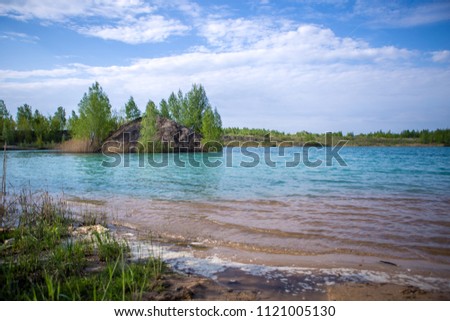 Image of azure river, hilly coast with green trees