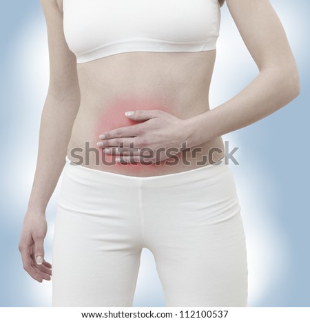 Acute pain in a woman belly. Female holding hand to spot of belly-ache. Concept photo with Color Enhanced skin with read spot indicating location of the pain.
