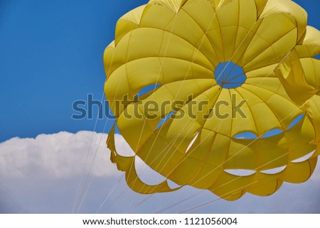 dome of the yellow parachute on the blue sky.