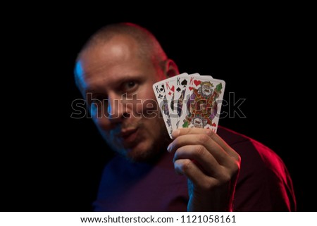 A man holds a deck of cards and shows tricks in a scenic light.
The photographer is the author of the design of playing cards, which is written in the release of the property.