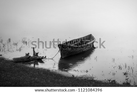 Wooden fishing boat on water.Black and white photography