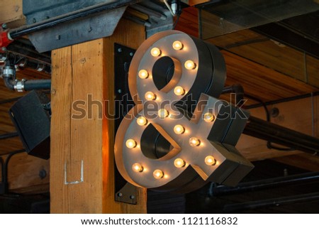 Lighted ampersand sign hanging from ceiling