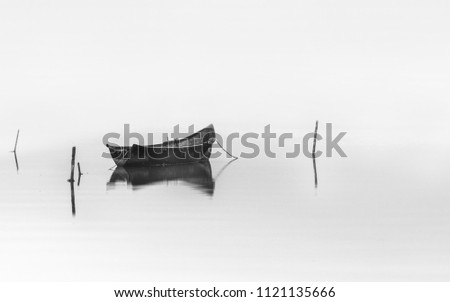 Wooden fishing boat on water.Black and white photography