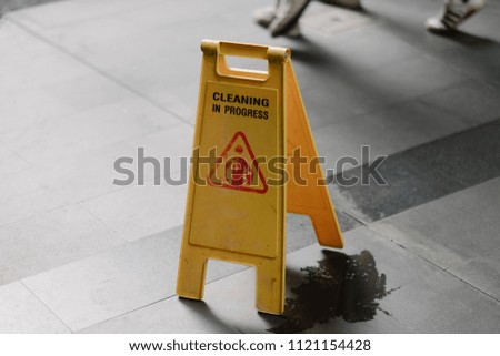 Sign showing warning of caution wet floor whitin airport.