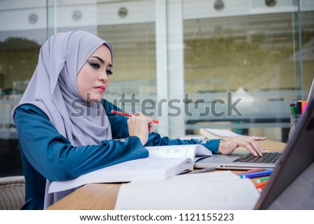 A beautiful muslim businesswoman working with computer in a cafe. Business team meeting brainstorming working concept.