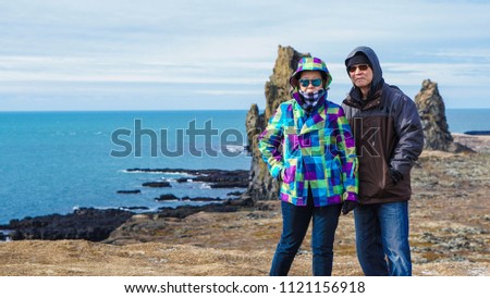 Asian senior couple photo with Iceland pennisula rock landmark