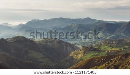 morning mist in the mountain peaks on natural landscape. Green valley on background foggy dramatic sky, mountain tops. Panorama horizon perspective view of scenery hills Northern Spain. Travel concept