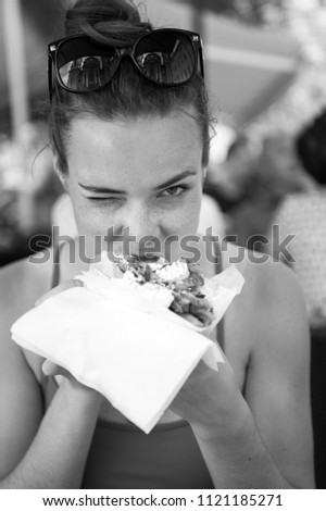 pretty girl or Woman eating sandwich gyros. Girl with pleasure eats burger after diet. She opened her mouth, holding a gyros on his outstretched hands and closed her eyes.