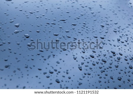 A drop of rain on a metal surface. drops of water on a metal surface closeup. water drops background. Water drops collect on top of metallic car surface