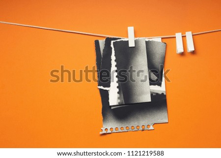 Old cards torn hung with the clothespins, orange background