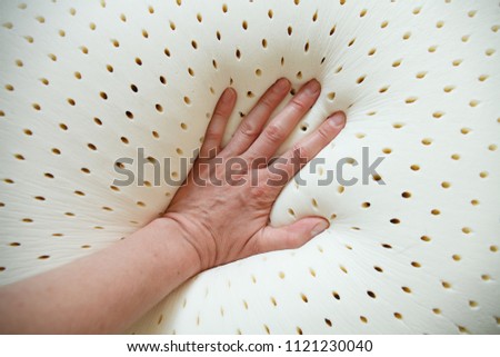 perforated latex mattress and pillow texture with hand on it Royalty-Free Stock Photo #1121230040