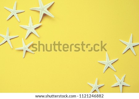 close up group of white star fish on yellow background with vintage color filter for summer season concept