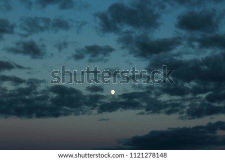 Gorgeous bright moon and few clouds on dark blue night sky. Amazing nature background.