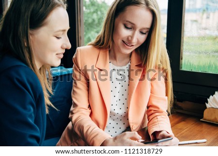 Two girls communicate at a meeting in a cafe.