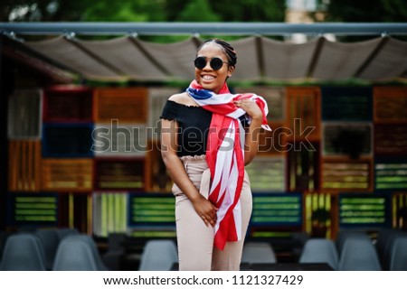 Stylish african american woman in sunglasses posed outdoor with usa flag.