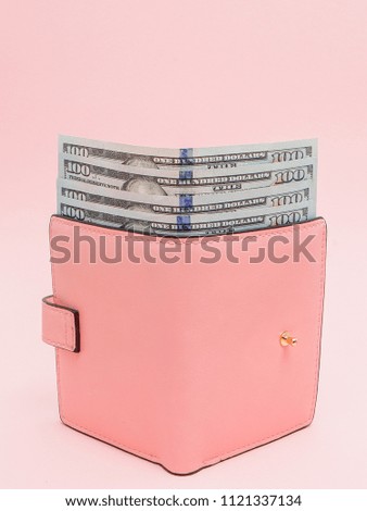 Purse with one hundred dollars banknotes on pink background. Flat lay, top view, copy space.