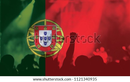 football fans supporting Portugal - crowd in stadium with raised hands against Portugese flag 