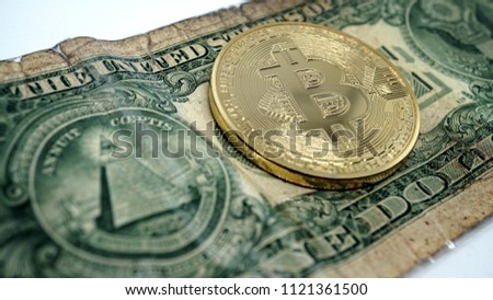 golden bitcoin coin on a one dollar bill in detail