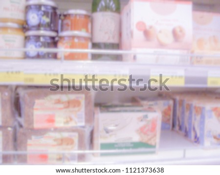 Defocused background with shelves full of grocery goods in a supermarket or hypermarket convenience store. Intentionally blurred post production for bokeh effect