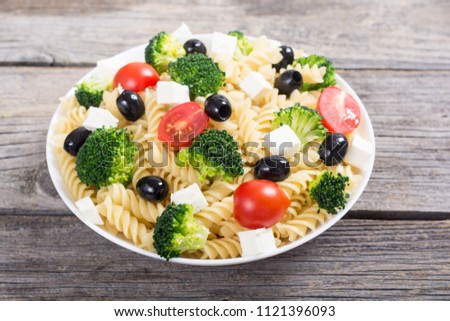 Pasta salad with ingridient : broccoli , tomatoes , feta and olives