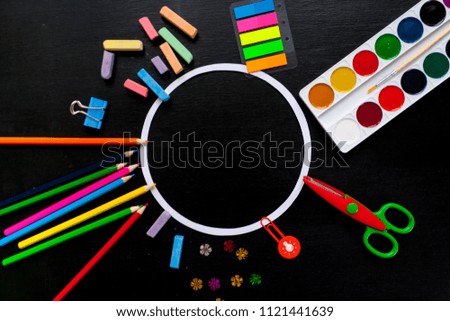 round frame with colorful pencils scissors on chalkboard background, space for text, flat lay, back to school concept