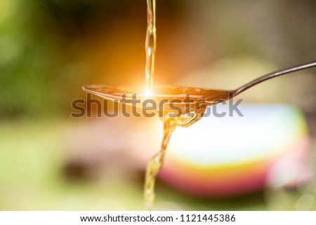 Extra virgin olive oil pouring over a spoon Royalty-Free Stock Photo #1121445386