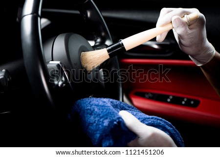 Car detailing series, Man use brush cleaning on hand wheel. Royalty-Free Stock Photo #1121451206