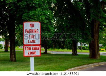 Red Letters on White Sign No Parking Sign in Fire Lane